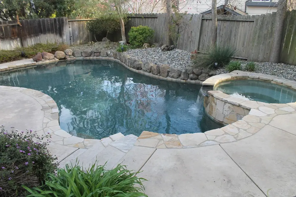 Freeform pool and spa with flagstone coping and clear water