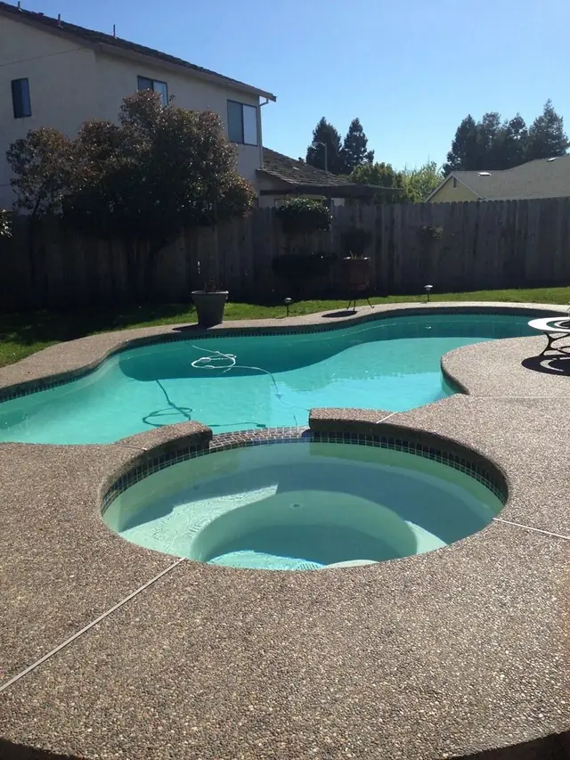 Pool and raised spa with an exposed-aggregate deck